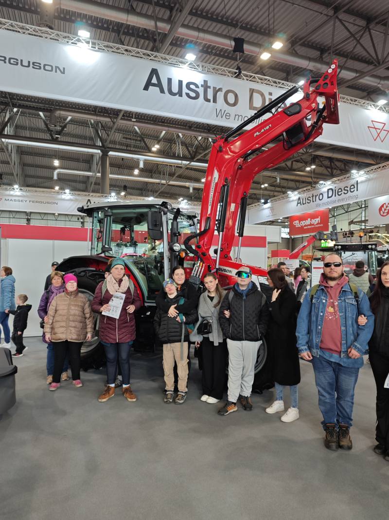 klienti a asistenti před traktorem na výstavě Agrishow