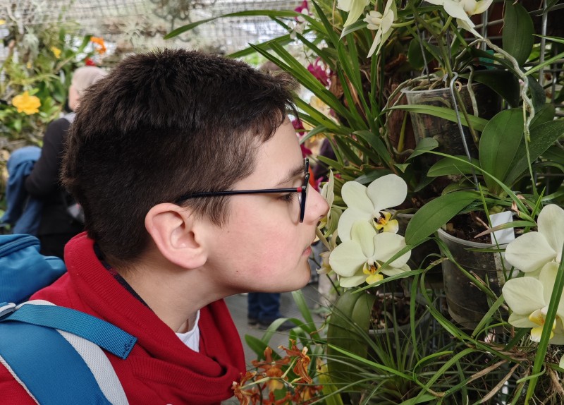 účastník poznávacího kroužku si přičichává k orchideji