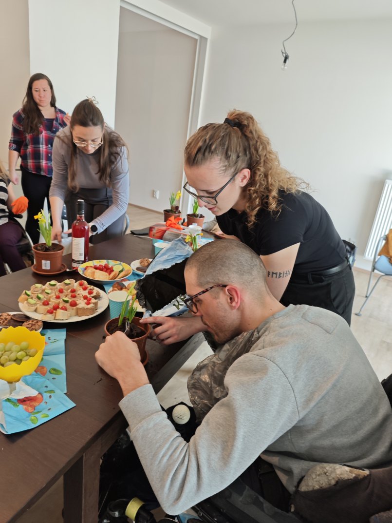 asistentka pomáhá klientovi s výrobou jarního květináče na Velikonoce