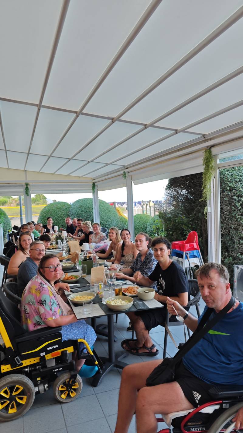 skupina klientů a asistentů u stolu při večeři poslední večer pobytu v Bibione